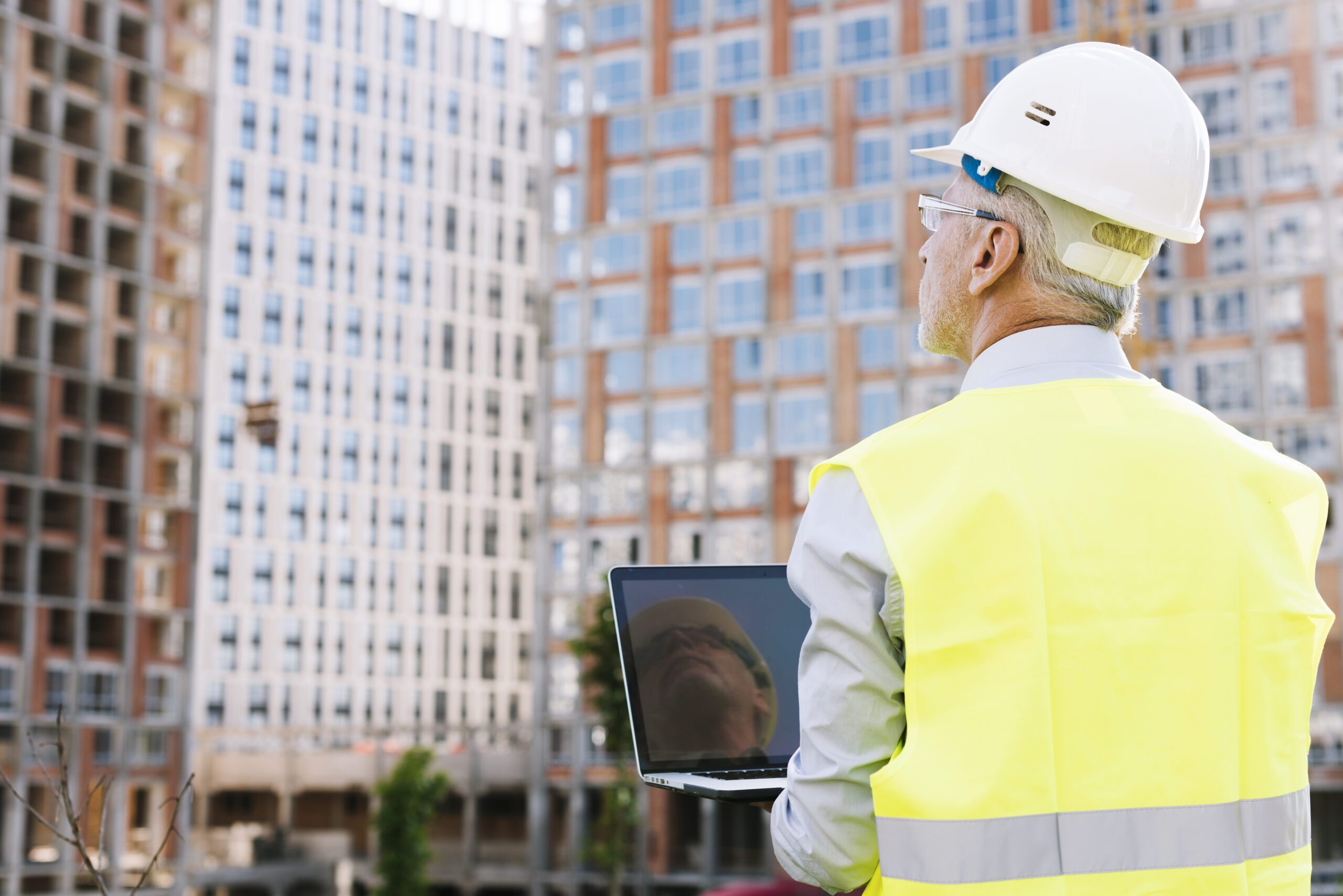 Ingeniero mirando edificios altos visto desde atrás